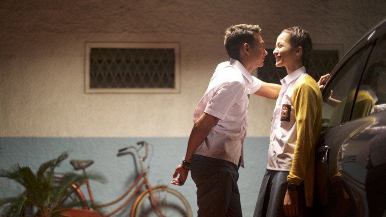 A close-up of Lala and Yudhis, their faces inches apart, his hand gripping her wrist just a little too tightly