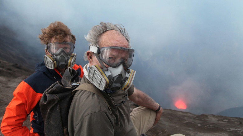 A slow-moving river of lava cuts through a blackened landscape, smoke curling into the sky.