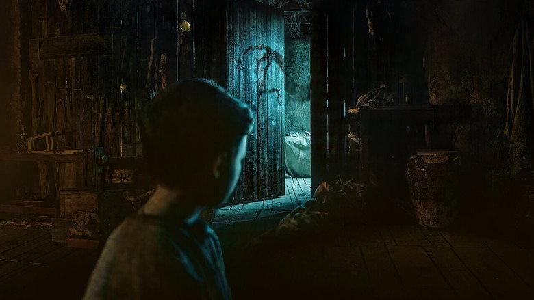 A lone figure stands in the doorway of a weather-beaten house, the wind whipping through the empty landscape.