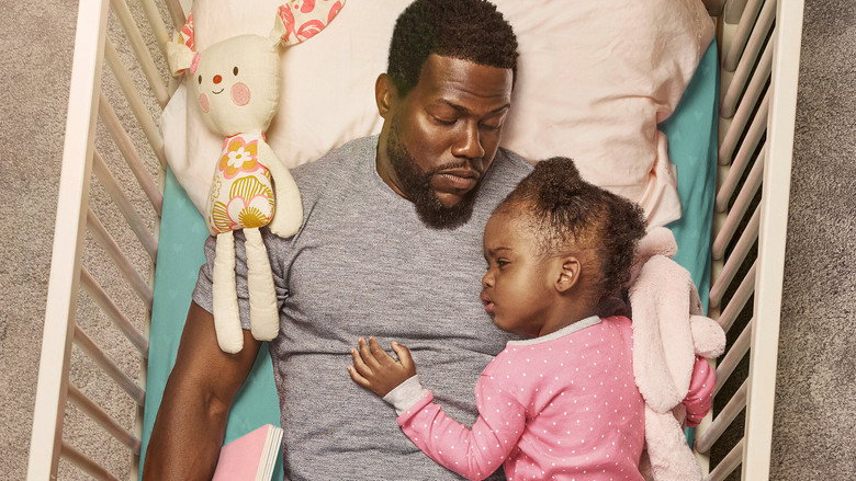 A father and daughter share a quiet moment on a couch, the soft light catching their faces as they read together