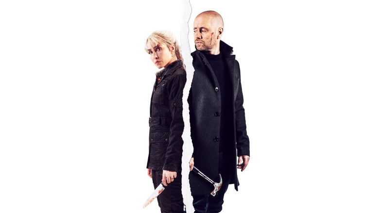 A dimly lit cabin interior, shadows stretching long across the wooden floor, as Noomi Rapace and Aksel Hennie stand on opposite sides of a kitchen island, tension thick enough to cut with the knife between them.