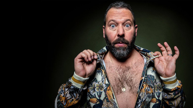 Bert Kreischer on stage, shirtless, mid-laugh, arms outstretched