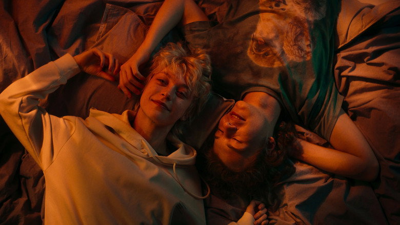 A black-and-white fantasy sequence where Tosiek, dressed in a grunge-inspired outfit, sings into a microphone with raw intensity.