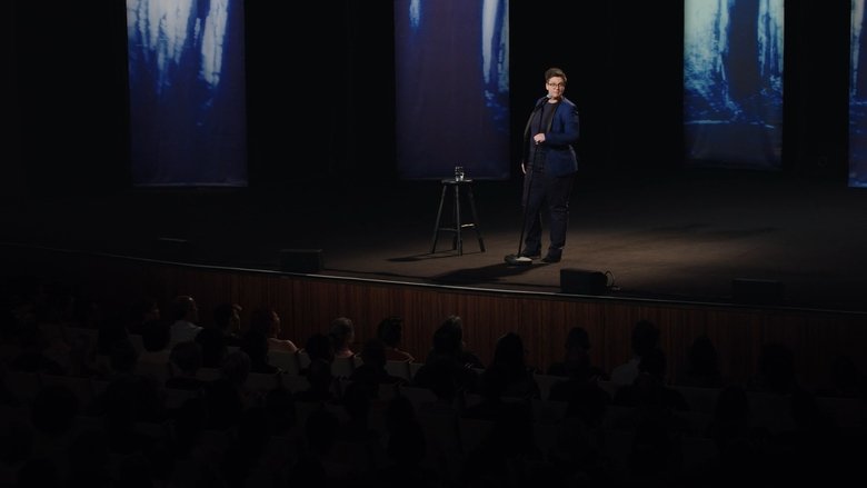 Hannah Gadsby on stage, mid-gesture, her face caught between a smile and something far more complicated