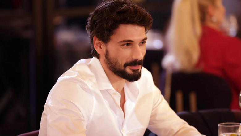 A woman looking over her shoulder in a rain-slicked street