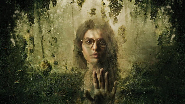 A shadowy figure looms in the dense forest, the trees forming a natural barrier between the characters and the unseen threat.
