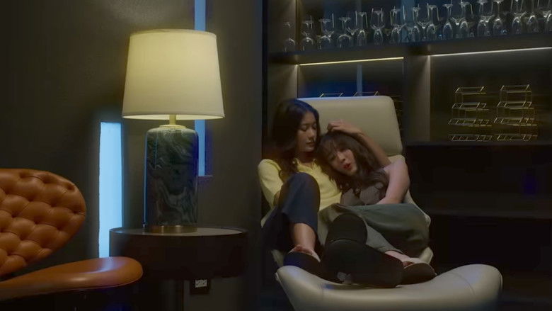 A moment of quiet, stolen intimacy between two characters, framed by the cold, sterile light of an urban interior.