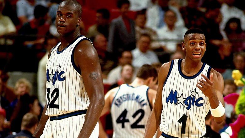 Shaquille O'Neal and Penny Hardaway mid-game, their faces locked in concentration, the weight of expectation pressing down on them.