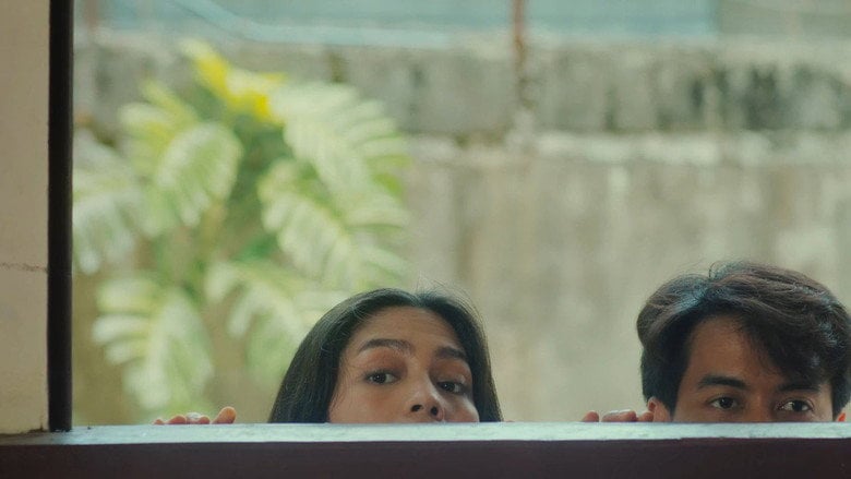 Ayla and Paolo sit on a bed, their backs to each other, the weight of exhaustion visible in their slumped shoulders.