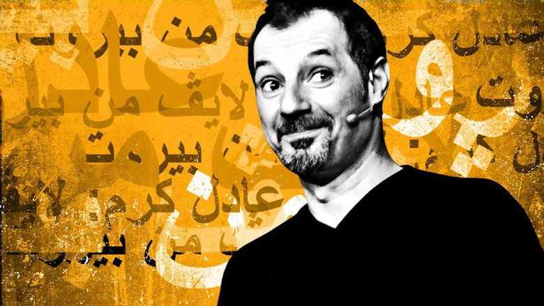 Adel Karam mid-laugh on stage, his face lit with the kind of unguarded joy that makes you wonder if he’s in on a joke the rest of us haven’t heard yet.