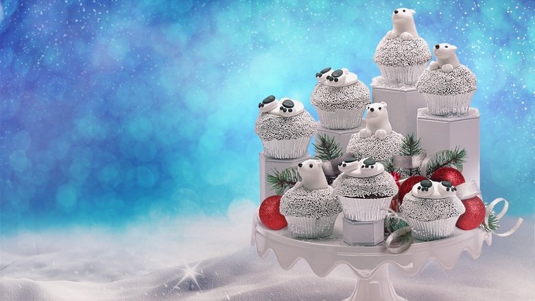 A team of bakers frantically decorates a towering Christmas cake under bright studio lights, their workspace littered with piping bags and edible glitter.