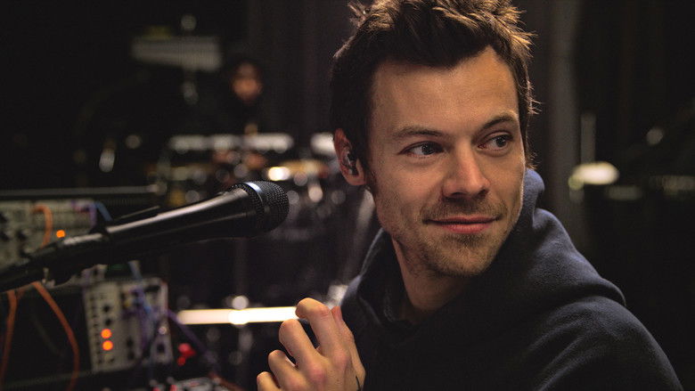 A wide shot of the Manchester stadium at twilight, with the stage glowing like a singular spark in the dark.