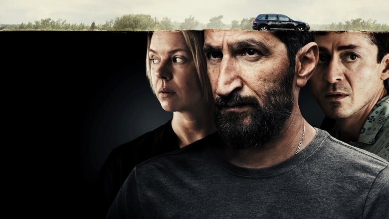 A tense standoff in a dimly lit car, the camera tight on the faces of Artan and Louise, their expressions a mix of exhaustion and simmering anger.