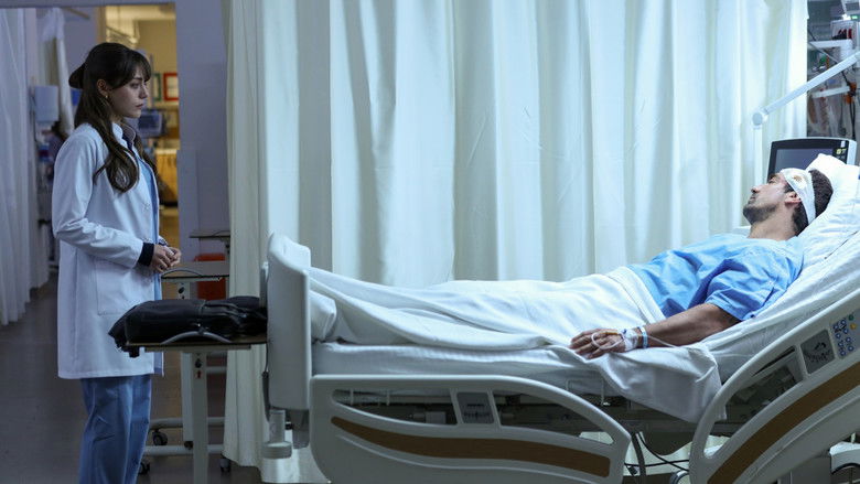 The lead character stands in a cold, blue-lit corridor looking disoriented