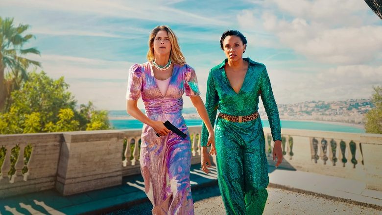 Léo and Mélanie stand on a sunlit street in Nice, their expressions a mix of frustration and reluctant curiosity.