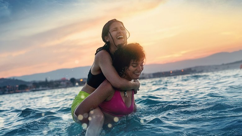 The sisters Yusra and Sara Mardini, mid-stroke in a training pool, their faces set in determination.