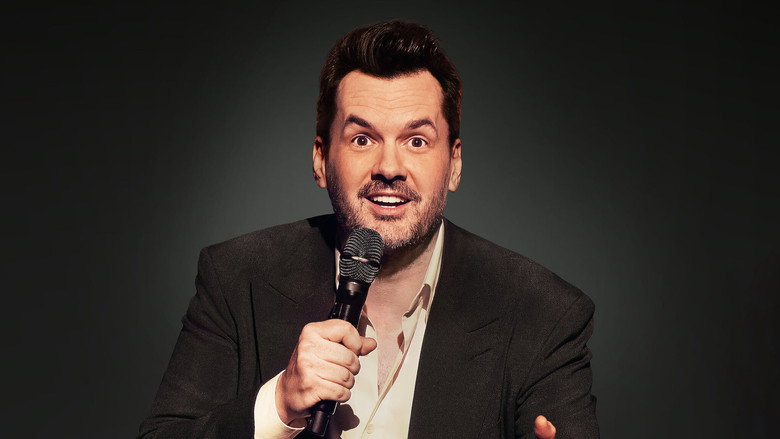 Jim Jefferies on stage, mid-gesture, his face lit with the kind of grin that suggests he’s about to say something you’ll regret laughing at