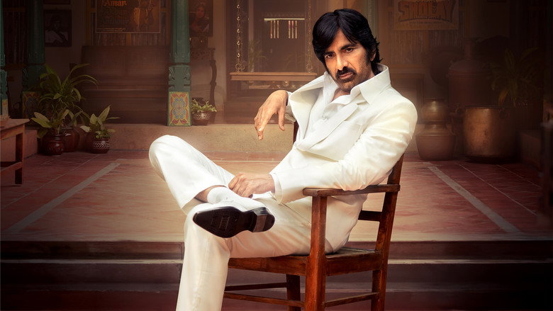 A dimly lit hallway in a politician’s mansion, shadows stretching long across marble floors, as Ravi Teja’s character stands poised with a flashlight, the tension palpable but undercut by the film’s tonal whiplash.