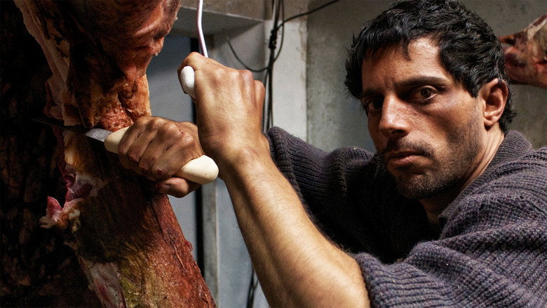 A dimly lit butcher shop, the counter slick with blood, the air thick with the metallic scent of meat. The camera lingers on the tools of the trade—knives, hooks, a scale—each one a promise and a threat.