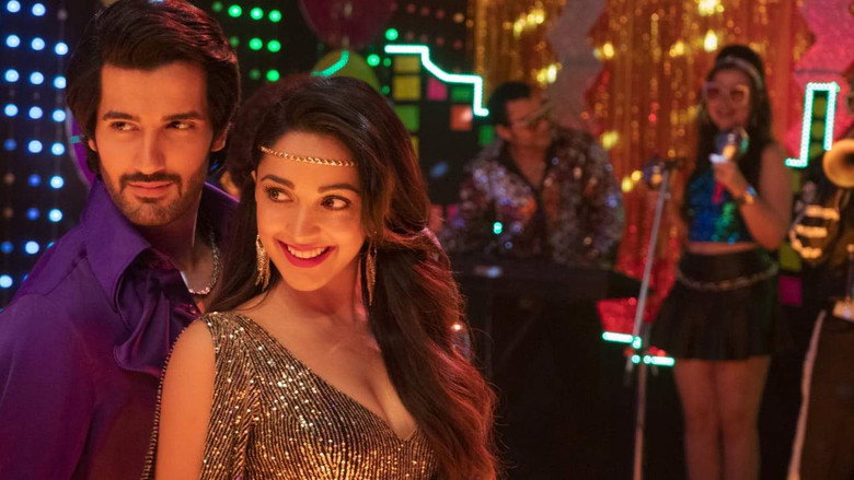 A still from *Indoo Ki Jawani* showing Indoo in a bright, chaotic room, surrounded by friends and potential suitors, her expression a mix of exasperation and amusement.