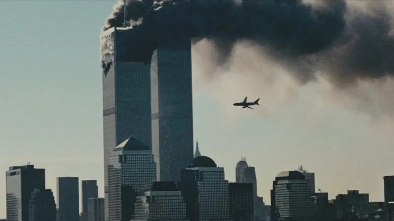A grainy archival shot of Lower Manhattan, smoke rising from the World Trade Center, the skyline forever altered