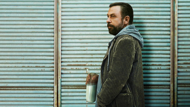 A close-up of the protagonist’s face, half in shadow, his expression caught between exhaustion and determination, a glass of whiskey untouched in front of him.