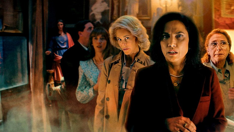 Three women in a dimly lit room, surrounded by paranormal investigation equipment, their faces lit by the glow of a single lamp.