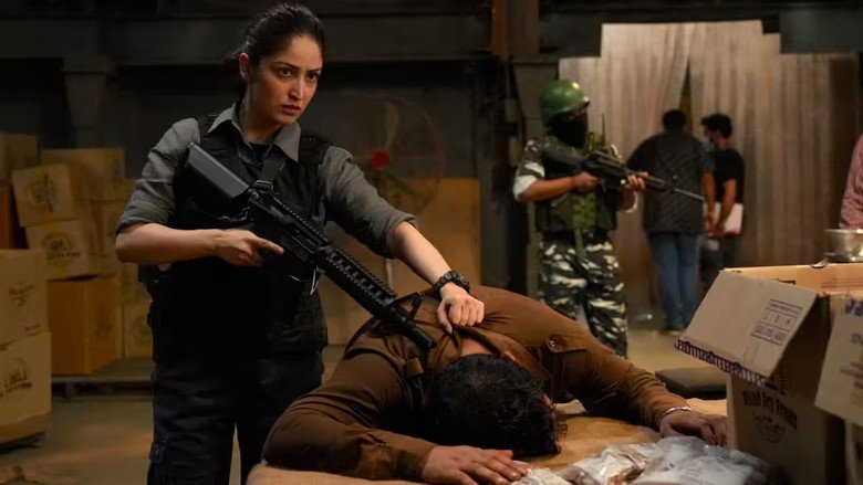 A tense standoff in a dimly lit room, where Yami Gautam’s character Zooni Haksar confronts a militant, her expression a mix of resolve and exhaustion.