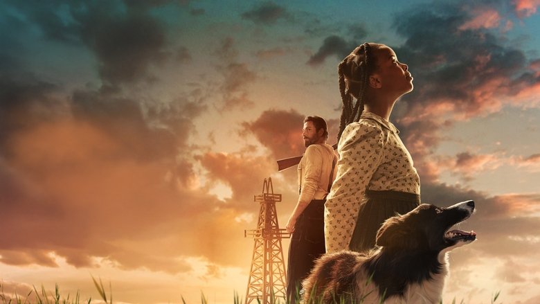 Sarah Rector standing firm against a backdrop of wooden oil derricks