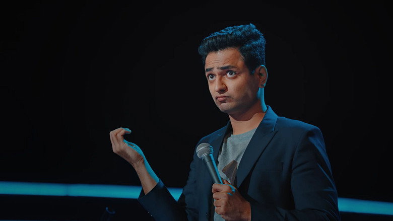 Kenny Sebastian mid-performance, guitar in hand, under warm stage lighting