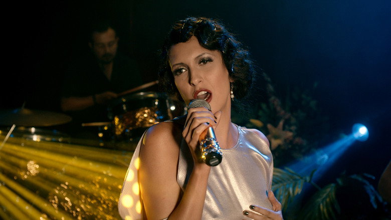 A dimly lit room where Martina sits alone, her posture slumped but her gaze sharp, as if daring the world to look away.