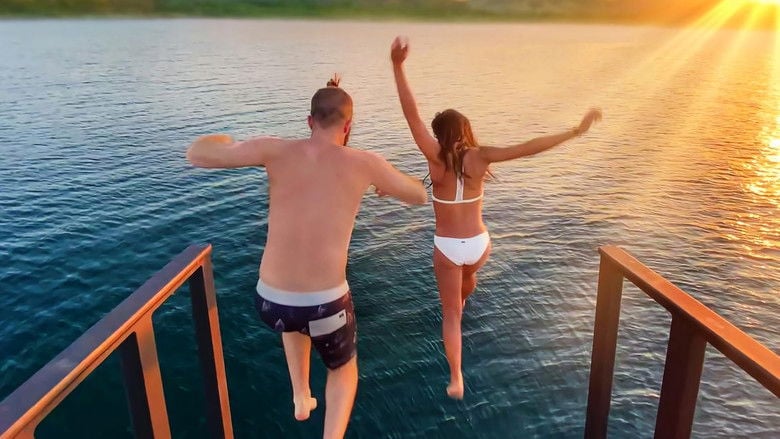 A sun-drenched balcony overlooking tropical foliage, the camera angled just enough to make the viewer feel like an intruder in someone else’s vacation