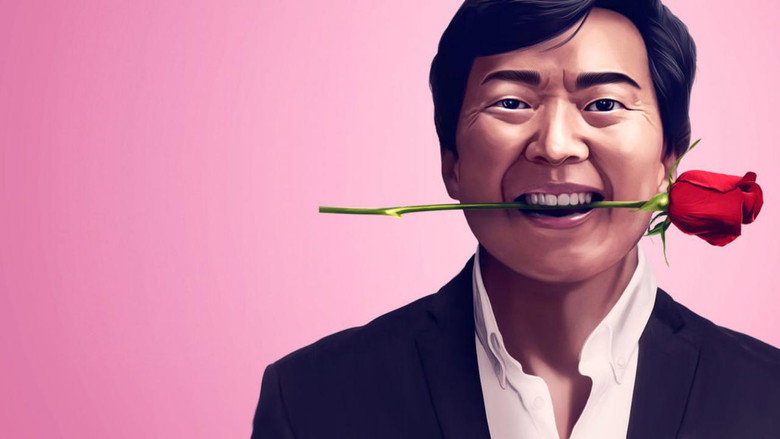 Ken Jeong on stage, mid-laugh, arms outstretched as if embracing an invisible audience