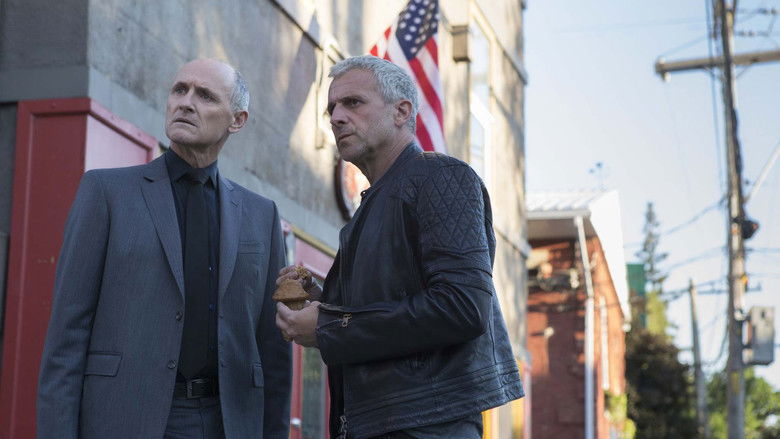 Martin Ward looks intently at a computer screen in a dim, blue-lit office