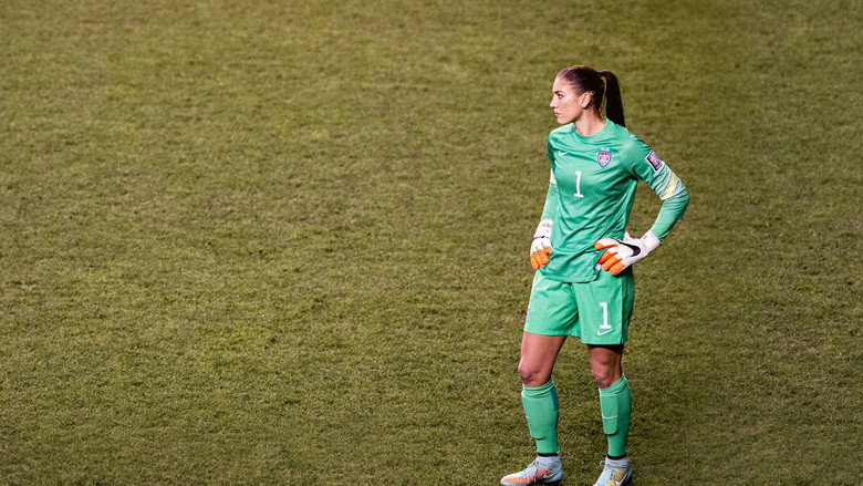 Hope Solo in goal, mid-game, her body coiled like a spring