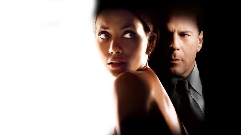 A scene of Halle Berry looking intensely at a computer screen, reflecting the blue light of the monitor