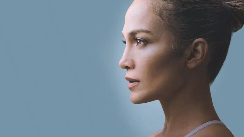 Jennifer Lopez mid-performance, bathed in neon light, her face a mix of determination and vulnerability