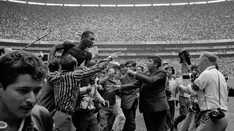 A young Pelé, mid-celebration, his face alight with joy after scoring a goal
