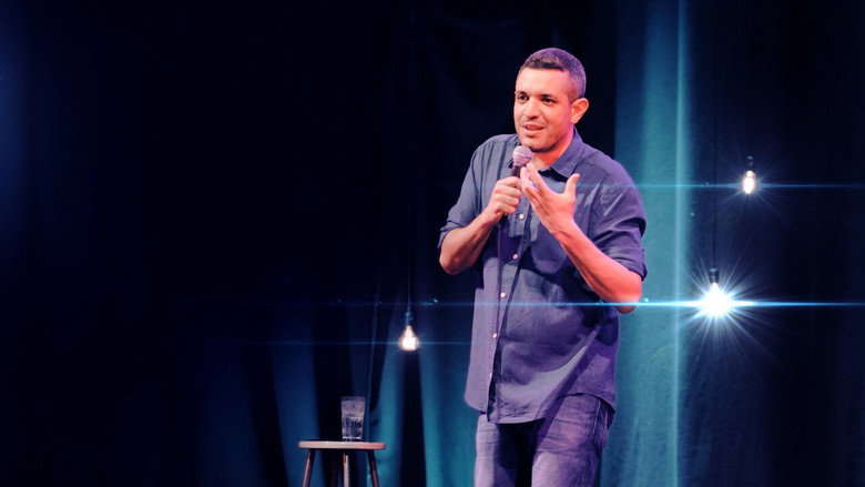 Francesco De Carlo on stage, mid-gesture, under a warm spotlight