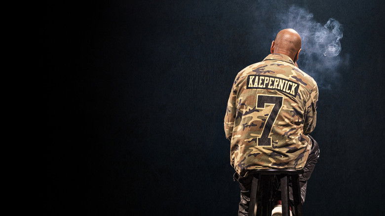 Chappelle on stage against a dark background