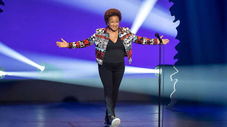 Wanda Sykes on stage, mid-gesture, her expression a mix of amusement and disbelief