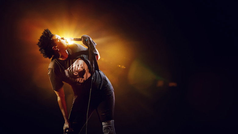 Leslie Jones mid-performance, arms outstretched, face alight with laughter