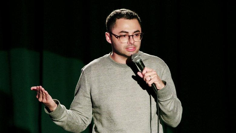 Joe Mande on stage, mid-joke, with a microphone in hand