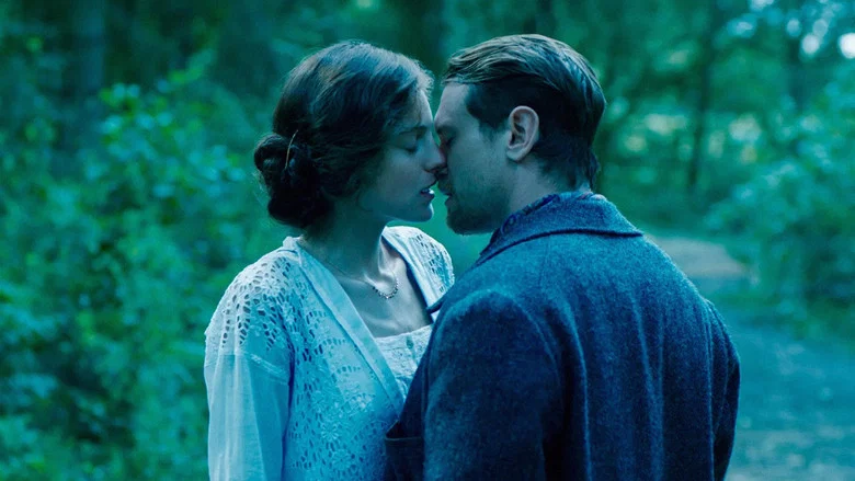 Connie and Mellors standing in a sunlit forest, their bodies close but not touching, the light filtering through the leaves like a veil.