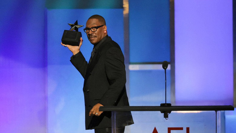 Eddie Murphy watching a montage of his career, his expression unreadable
