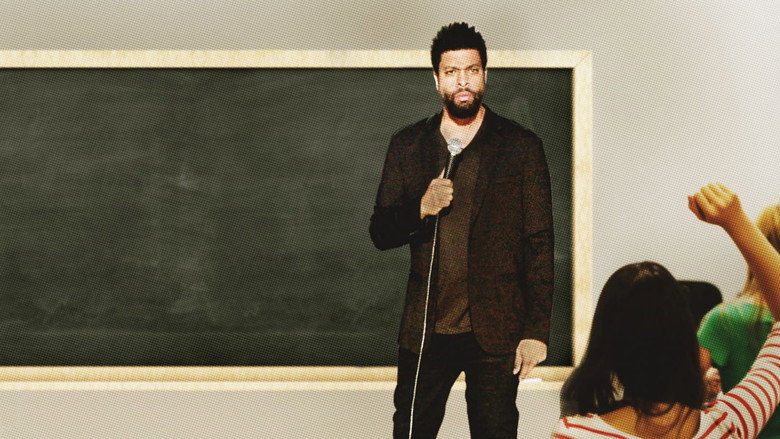 DeRay Davis on stage, mid-performance, arms outstretched as if inviting the audience into the joke.