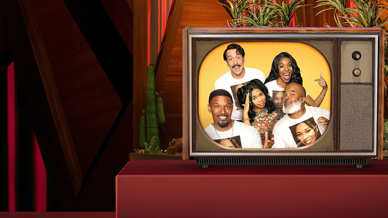 A brightly lit studio set with a curved couch, where the cast of *Dad Stop Embarrassing Me!* sits in a loose semicircle, laughing or mid-conversation.