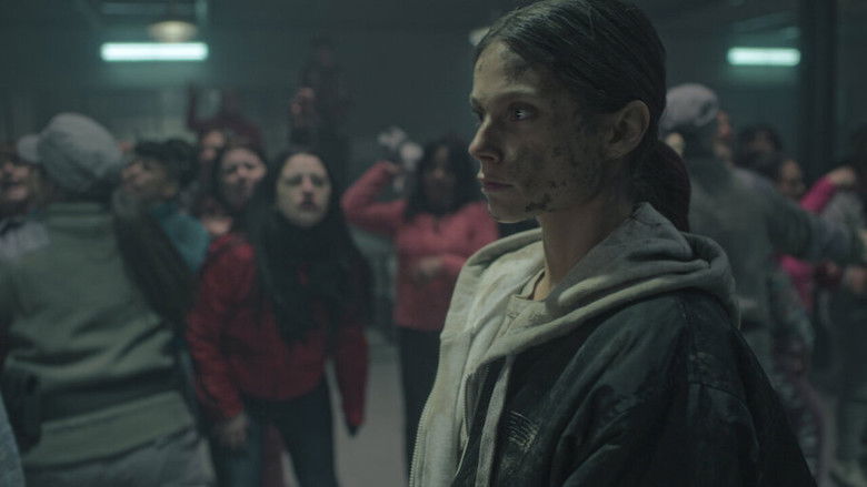 Gladys standing in the dimly lit prison corridor