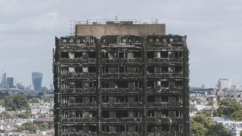 A towering inferno at night, flames licking the sides of a high-rise building, smoke billowing into the sky