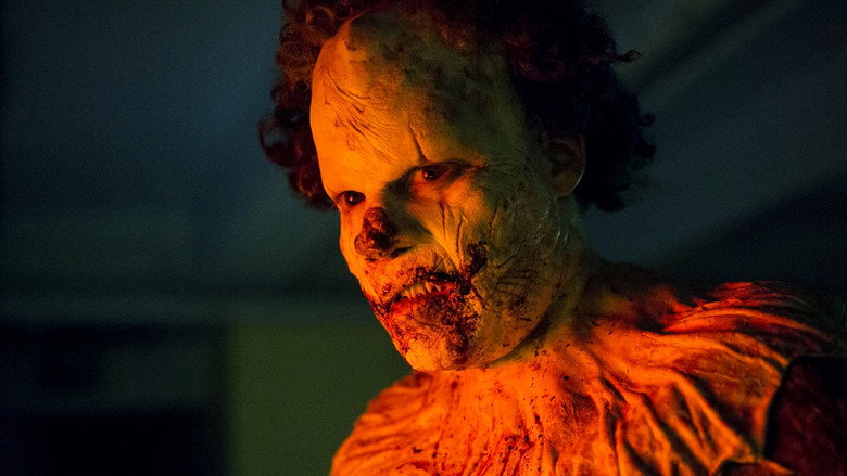 Kent McCoy in the clown suit, his face half-transformed into something grotesque and inhuman